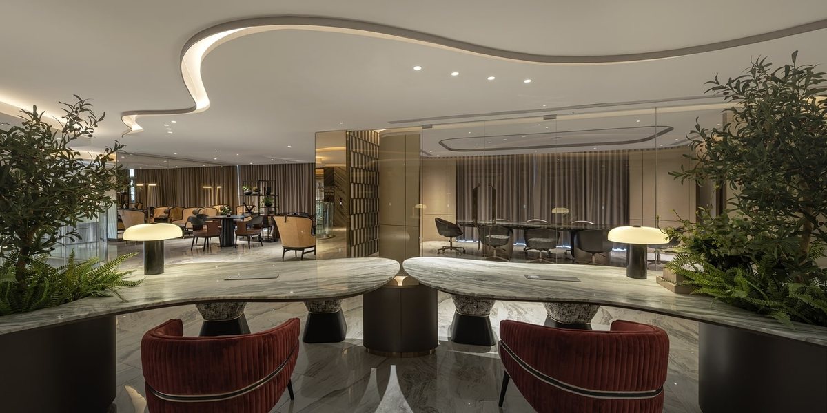 Lobby lounge with red armchairs and a curved ceiling
